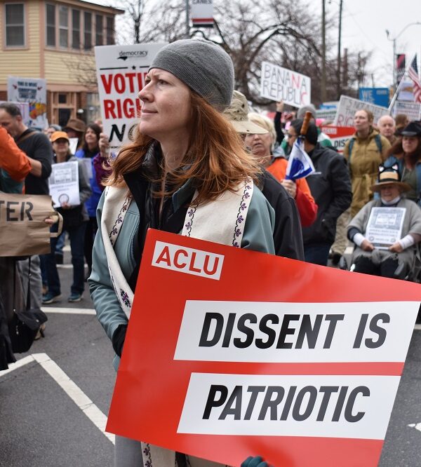 Protester holds an ACLU sign that says "Dissent is Patriotic"