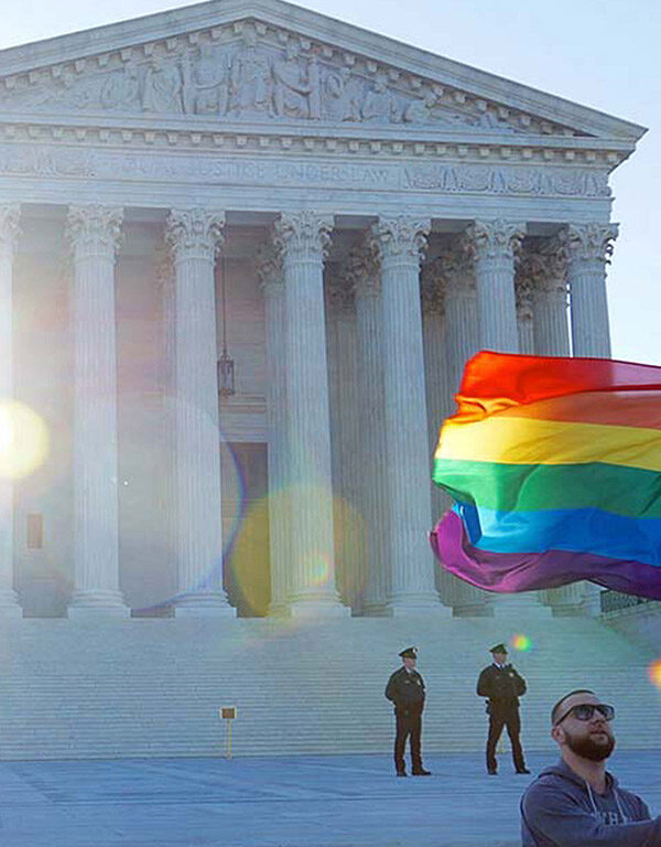 Man waving rainbow flag in front of Supreme Court
