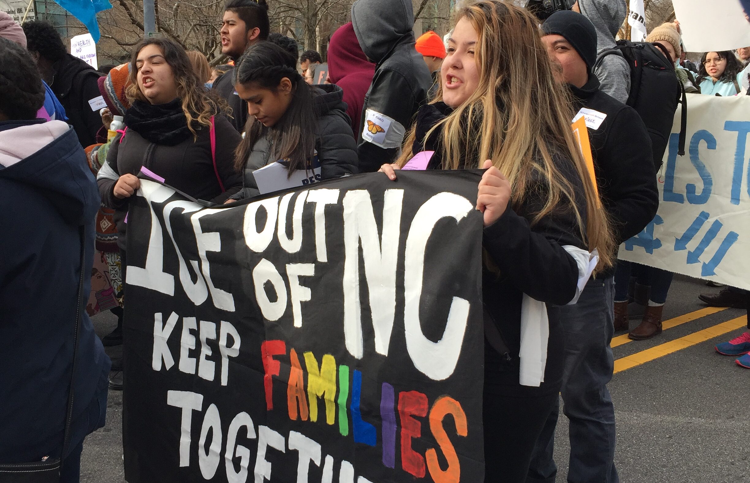 "Keep families together" sign at a rally