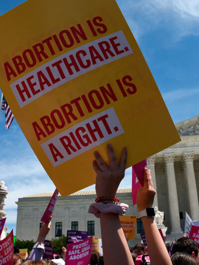 Protesters holding signs at abortion rally in front of Supreme Court