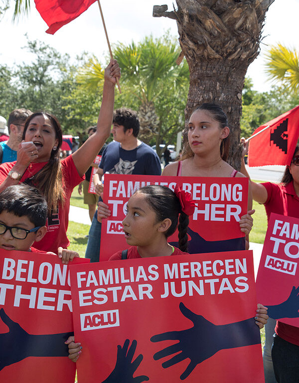 Demonstrators carrying signs with the text "Families Belong Together"