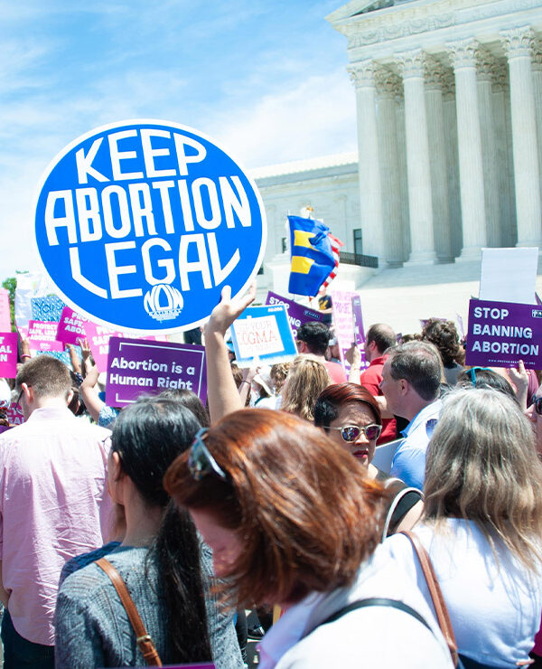 A crowd of pro-choice protesters standing outside the Supreme Court holding up signs that read "Keep Abortion Legal," and "Abortion is a Human Right" among other signs.