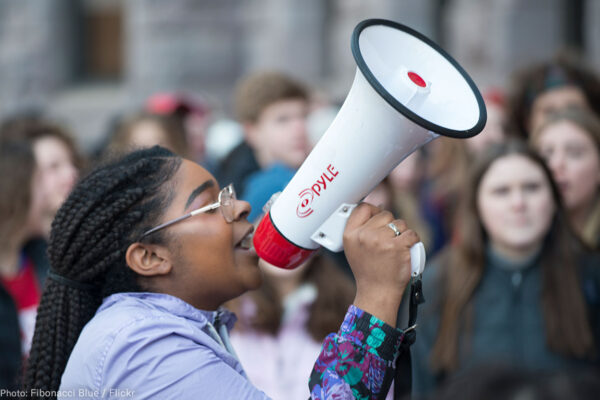 A Black woman speaks into a bullhorn