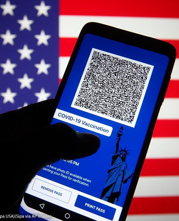 In this photo illustration, Excelsior Pass app which provides digital proof of COVID-19 vaccination or negative test results seen displayed on a smartphone screen in front of the US flag.