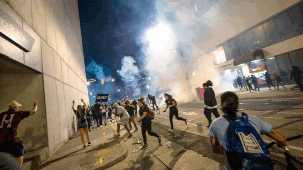 Protesters scramble on Fourth Street as police fire tear gas on either side of the protesters in uptown Charlotte on June 2, 2020. JOSHUA KOMER THE CHARLOTTE OBSERVER
