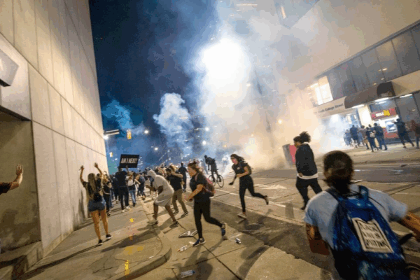 Protesters scramble on Fourth Street as police fire tear gas on either side of the protesters in uptown Charlotte on June 2, 2020. JOSHUA KOMER THE CHARLOTTE OBSERVER