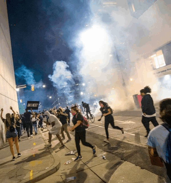 Protesters scramble on Fourth Street as police fire tear gas on either side of the protesters in uptown Charlotte on June 2, 2020. JOSHUA KOMER THE CHARLOTTE OBSERVER