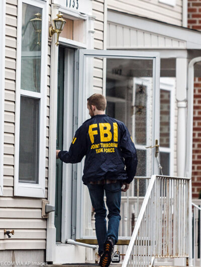 A member of the FBI enters a residence.