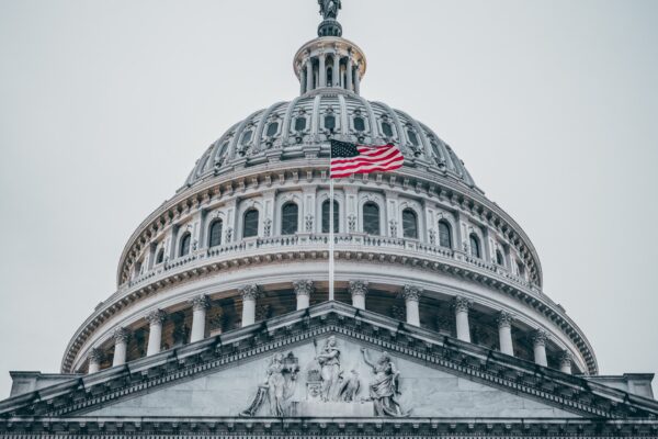 Photo of the U.S. Capitol with the flag waving in front.