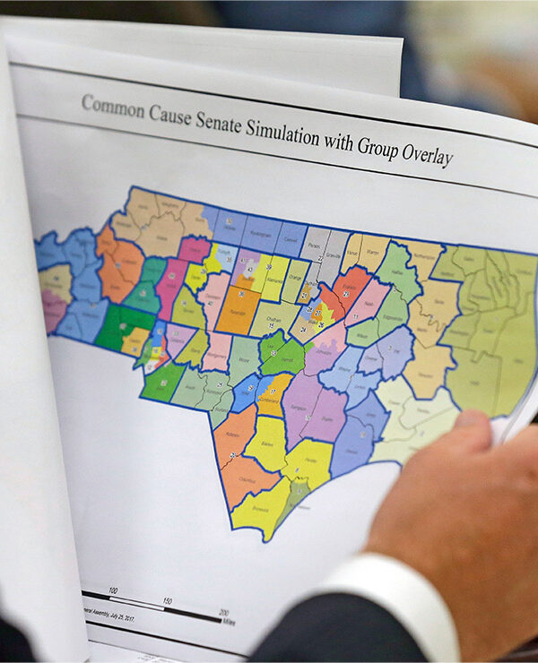 An elected official reviews a map of North Carolina districts at select committee meeting on redistricting.