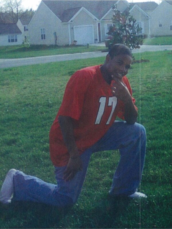 bacote kneeling in a football jersey