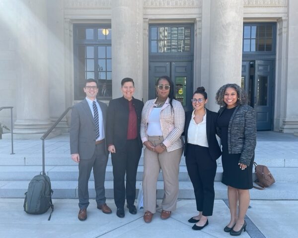 Five people stand in front of the Mecklenburg County Courthouse in Charlotte, NC. Names listed in caption.