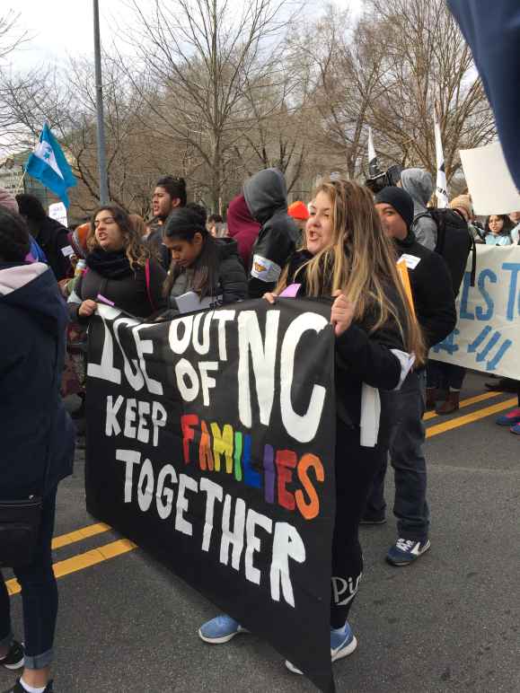"Keep families together" sign at a rally