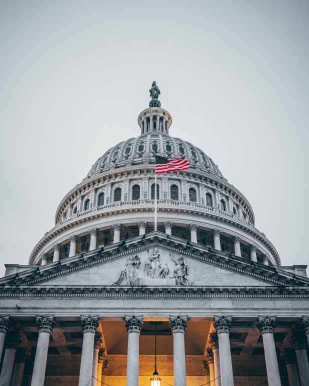 Photo of the U.S. Capitol with the flag waving in front.