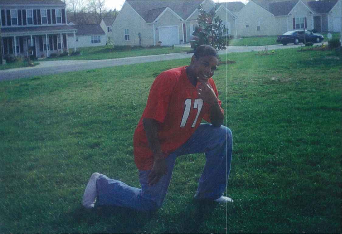 bacote kneeling in a football jersey