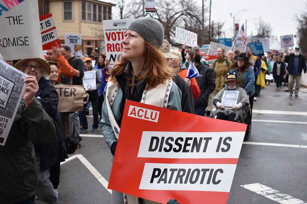 Protester holds an ACLU sign that says "Dissent is Patriotic"