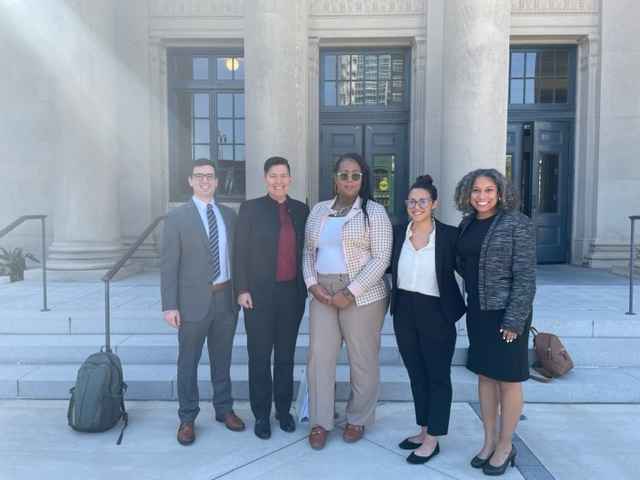 Five people stand in front of the Mecklenburg County Courthouse in Charlotte, NC. Names listed in caption. 