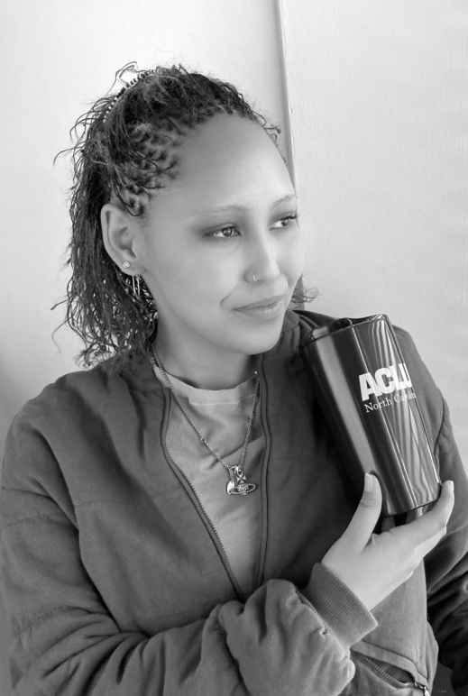 Black and white photo of Genna Marshall holding an ACLU tumbler