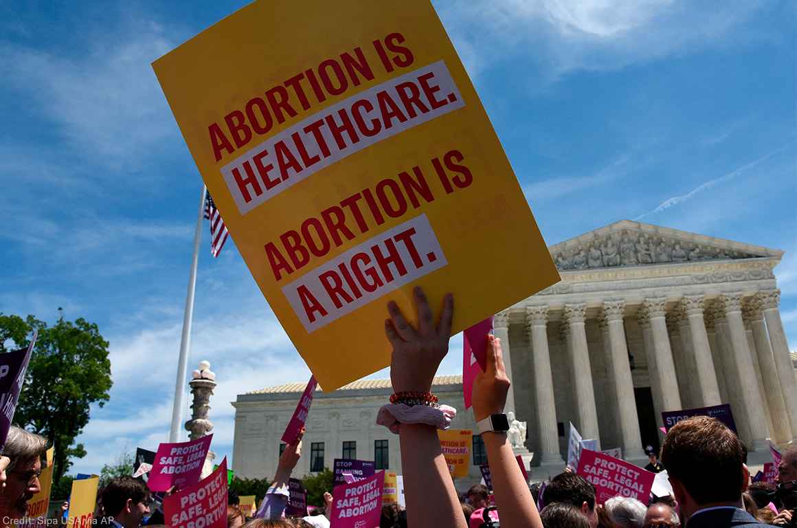 Protesters holding signs at abortion rally in front of Supreme Court