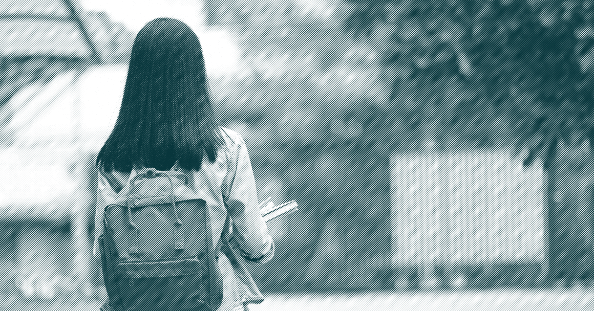 Photo from behind of young student wearing a backpack