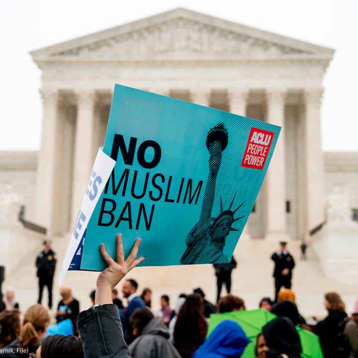 In this April 25, 2018 photo, a person holds up a sign that reads "No Muslim Ban" during an anti-Muslim ban rally at the Supreme Court
